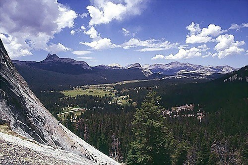 A climber on Crying Time Again on Lembert Dome; Cathedral Pk. can be s...