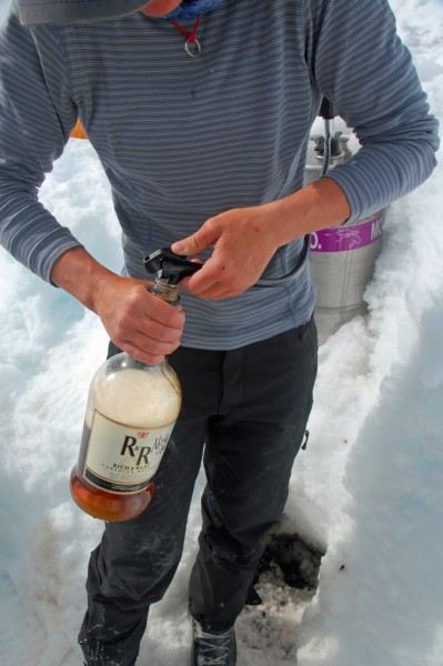 Lauren filling the &#40;empty&#41; bottle of whiskey with some of the ...