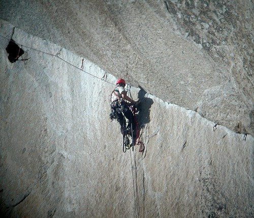 A climber cleaning the dramatic traverse on pitch 7 of The Shield. On ...