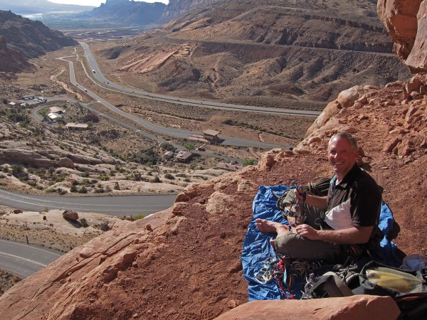 Racking up at the base of the 3 Penguins, Moab in the distance.  A sem...