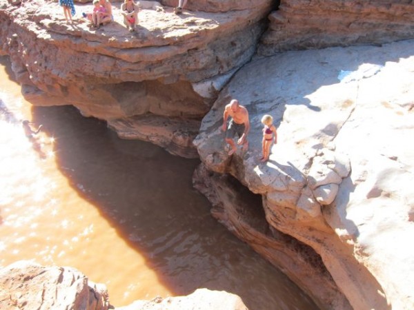 A dad jumps into the hole while the daughter watches