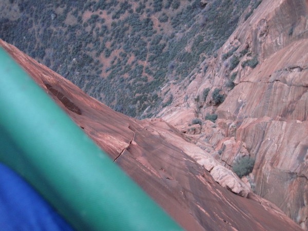 Looking over the lip of the ledge, pitch 6 belay