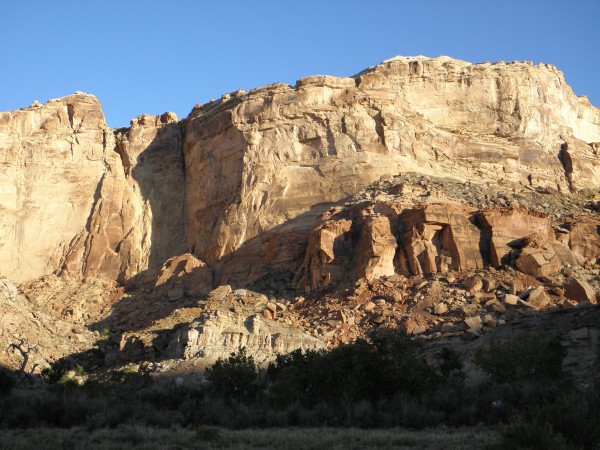 The cliffs of the Glen Canyon Group soar over the bottom lands at Toms...