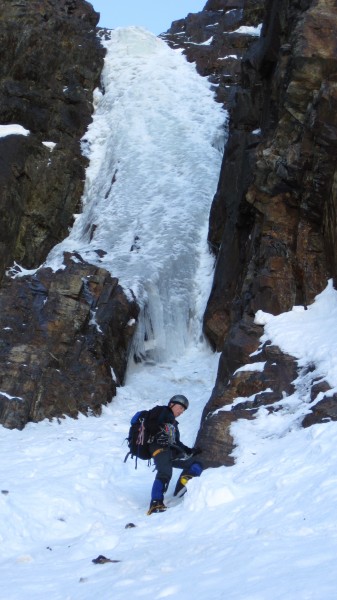 Partner setting up a belay in a protected spot below the rock buttress...